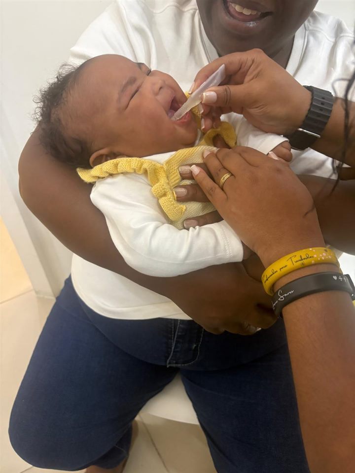 Bebê tomando vacina oral com atendimento acolhedor